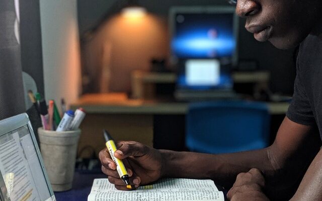 photo-of-man-reading-a-book-2574616